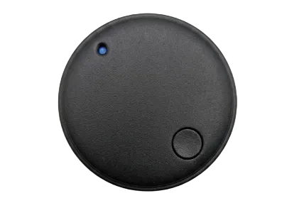 A round black electronic tracker device with a textured matte finish, featuring a small blue LED indicator light and a central button, shown from a top-down view on a white background.